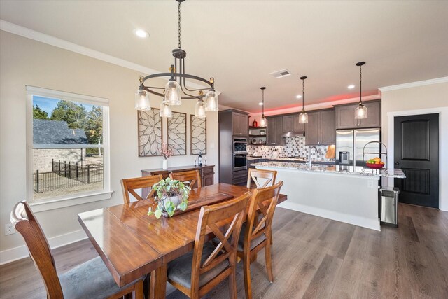 dining area featuring baseboards, visible vents, dark wood-type flooring, crown molding, and recessed lighting