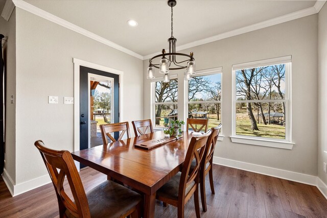 dining area featuring dark wood finished floors, crown molding, and baseboards