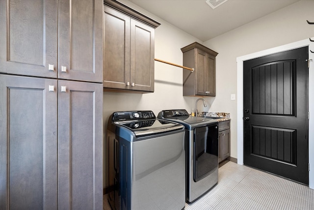 laundry area featuring visible vents, separate washer and dryer, a sink, and cabinet space