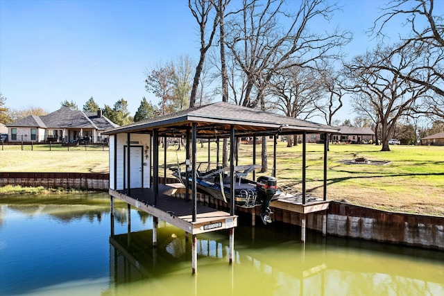 view of dock with a yard, a water view, and boat lift