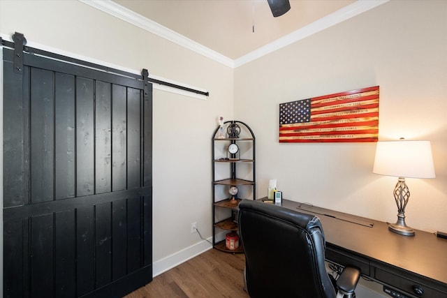 office space featuring a barn door, baseboards, ceiling fan, ornamental molding, and wood finished floors