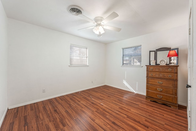 unfurnished room featuring dark wood-type flooring and ceiling fan