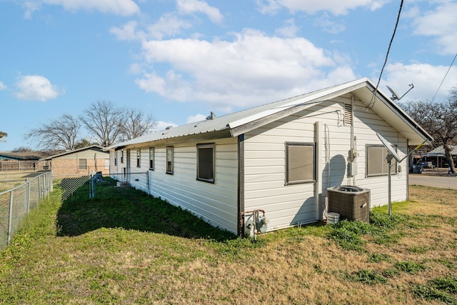 rear view of property with a yard and central AC unit