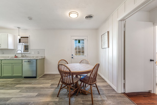 dining space with ornamental molding, dark wood-type flooring, and sink