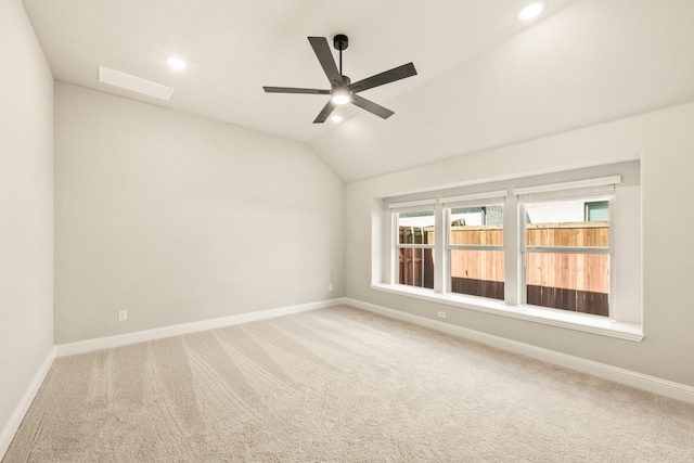 unfurnished room featuring carpet, baseboards, and vaulted ceiling