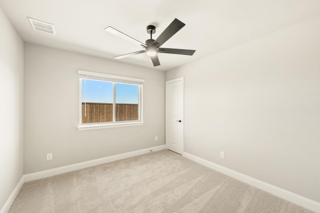 empty room featuring visible vents, ceiling fan, light carpet, and baseboards