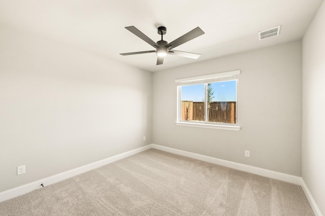 empty room featuring ceiling fan, carpet floors, visible vents, and baseboards