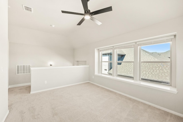 carpeted spare room featuring a ceiling fan, visible vents, and baseboards