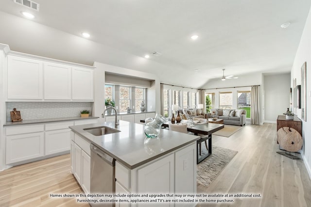 kitchen featuring white cabinets, a center island with sink, stainless steel dishwasher, and sink