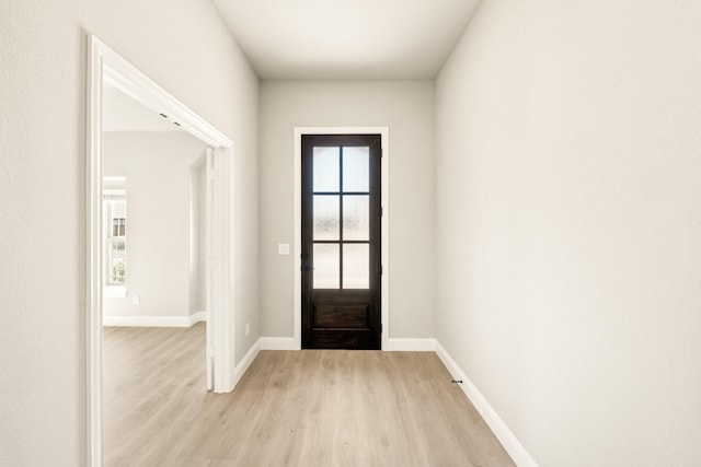 foyer entrance with light wood-style floors and baseboards