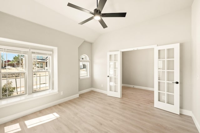 unfurnished room with french doors, a ceiling fan, vaulted ceiling, wood finished floors, and baseboards