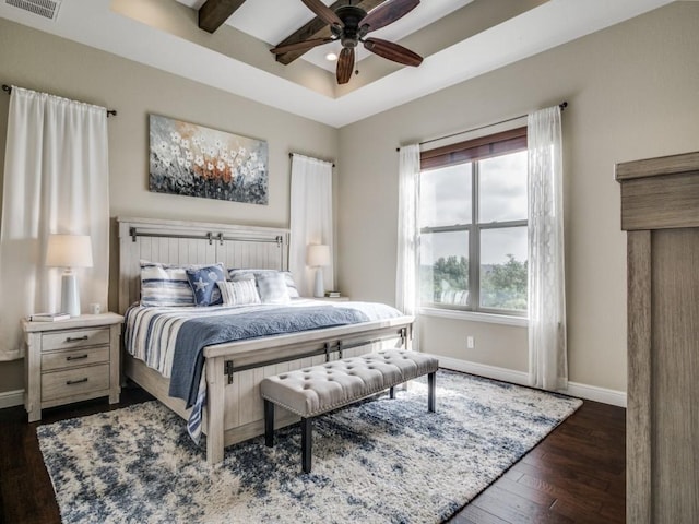 bedroom featuring dark wood-type flooring, ceiling fan, and a tray ceiling