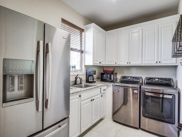 washroom featuring cabinets, separate washer and dryer, sink, and light tile patterned floors