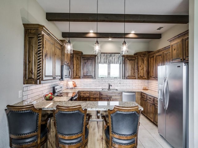 kitchen featuring tasteful backsplash, stainless steel appliances, kitchen peninsula, and hanging light fixtures