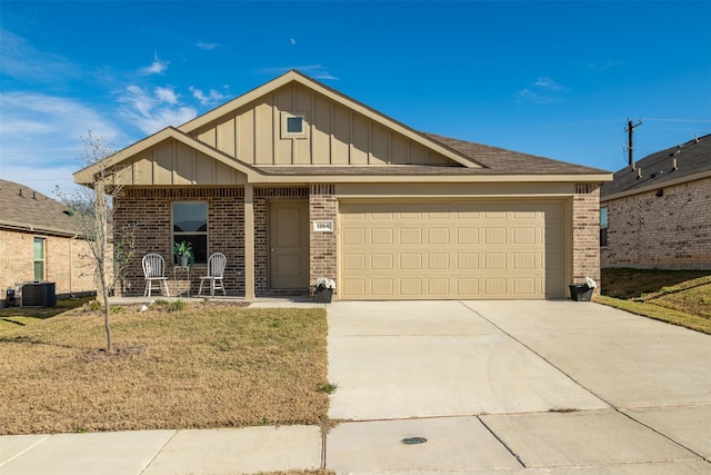 view of front of property featuring a front yard, a garage, and central air condition unit