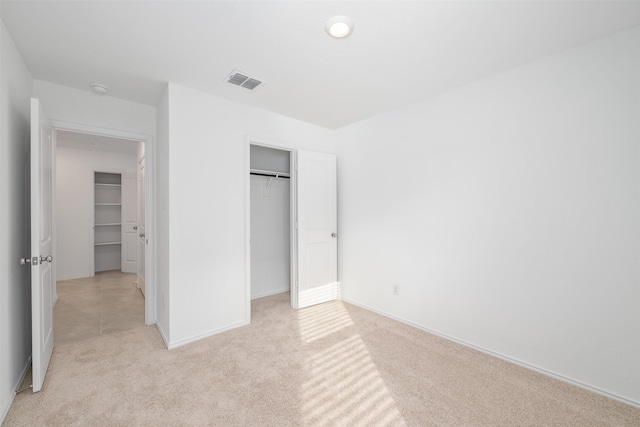 unfurnished bedroom featuring light carpet and a closet