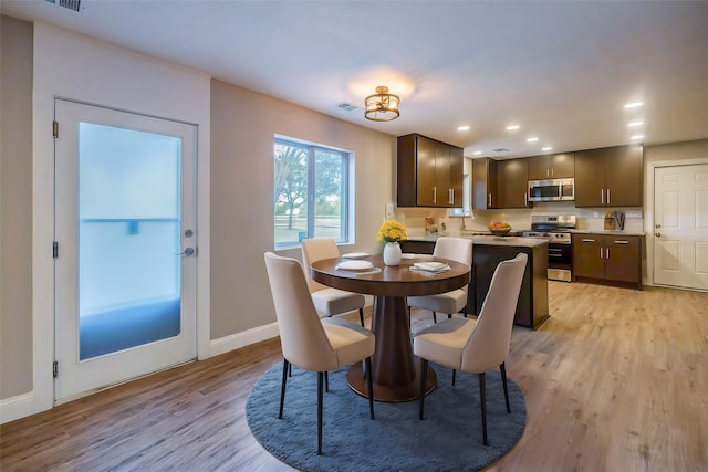 dining room with light wood-type flooring and sink