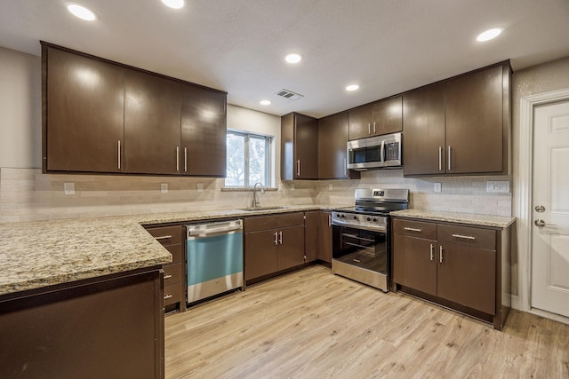 kitchen with sink, stainless steel appliances, and dark brown cabinets