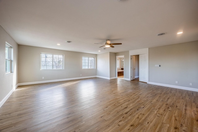 empty room with hardwood / wood-style floors, a wealth of natural light, and ceiling fan