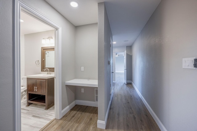 hall featuring light hardwood / wood-style flooring and sink