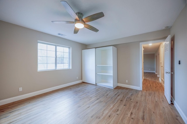 unfurnished bedroom featuring ceiling fan, light wood-type flooring, and a closet