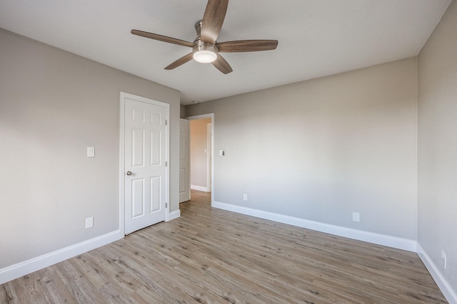 spare room with ceiling fan and light wood-type flooring