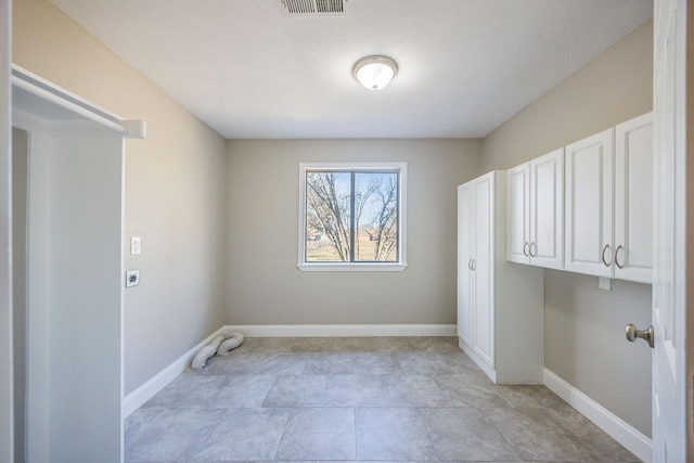 laundry area with electric dryer hookup and cabinets