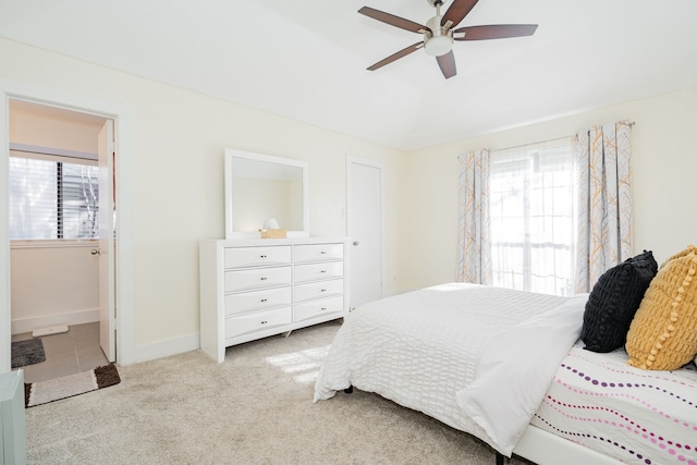 bedroom with connected bathroom, ceiling fan, and light carpet