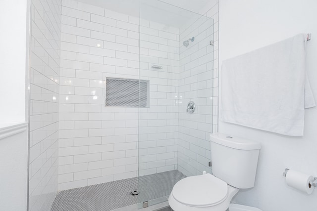 bathroom with tiled shower and toilet