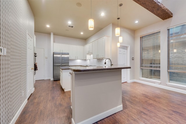 kitchen with stainless steel fridge, tasteful backsplash, dark wood-type flooring, pendant lighting, and white cabinetry