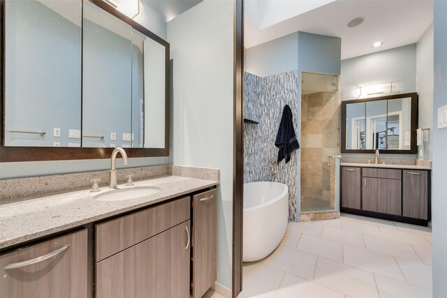 bathroom featuring plus walk in shower, vanity, and tile patterned flooring