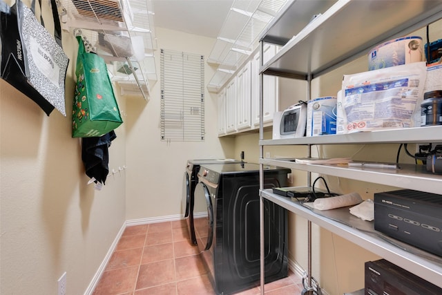 washroom with washer and dryer, cabinets, and light tile patterned flooring