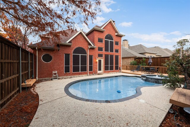 view of swimming pool with a patio area and an in ground hot tub