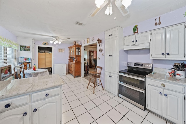 kitchen with under cabinet range hood, double oven range, visible vents, and white cabinetry