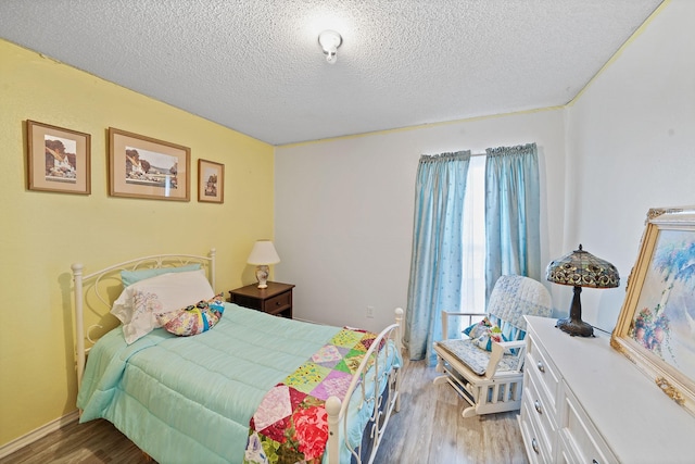 bedroom featuring a textured ceiling and wood finished floors