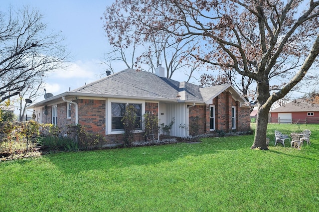 ranch-style house featuring brick siding, fence, roof with shingles, a chimney, and a front yard