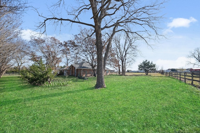 view of yard featuring fence and a rural view