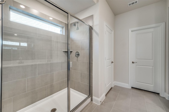 bathroom featuring a shower with shower door and tile patterned floors