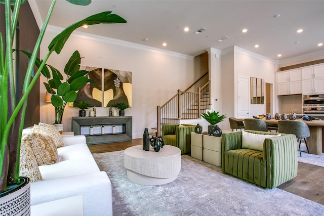 living room featuring wood-type flooring and crown molding