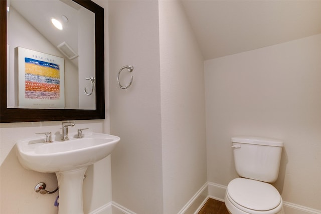 bathroom with toilet and lofted ceiling