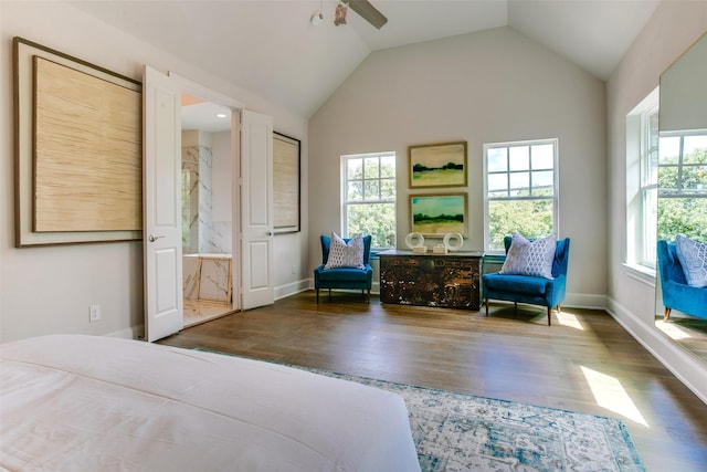 bedroom with ceiling fan, vaulted ceiling, multiple windows, and ensuite bath