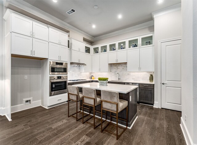 kitchen featuring light wood-type flooring, tasteful backsplash, white cabinetry, and sink