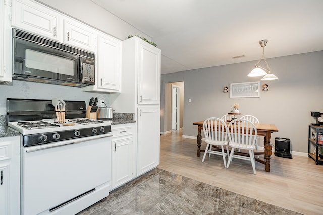 kitchen with white cabinets, light hardwood / wood-style floors, white gas range, and hanging light fixtures