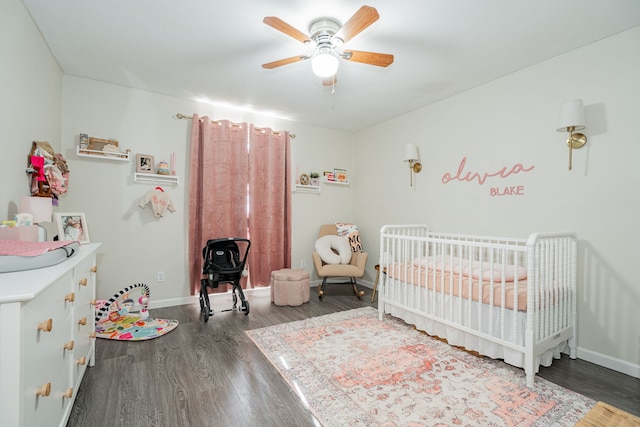 bedroom with ceiling fan, dark hardwood / wood-style flooring, and a nursery area