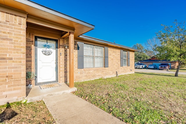 entrance to property with a lawn