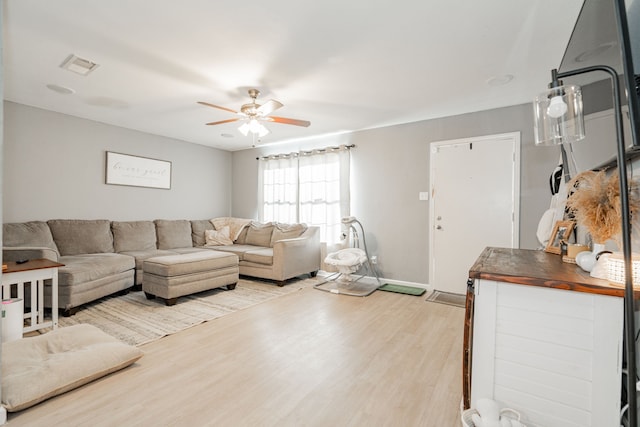 living room featuring light hardwood / wood-style flooring and ceiling fan