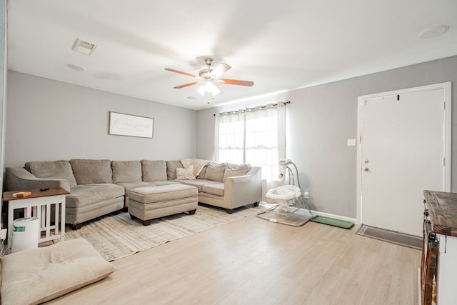 living room featuring ceiling fan and light hardwood / wood-style floors