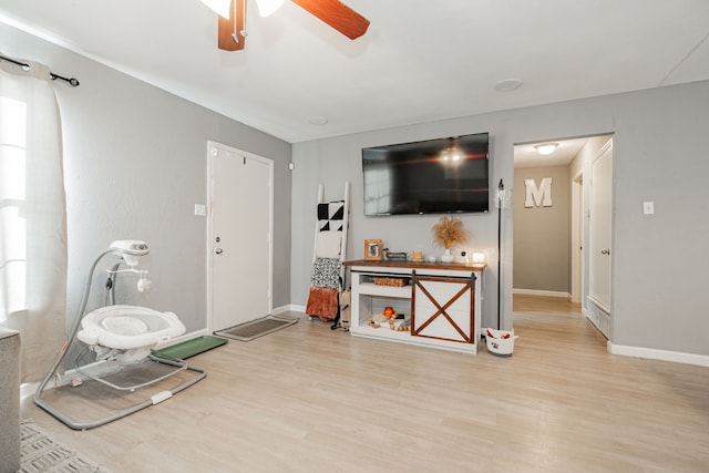 living room featuring light hardwood / wood-style flooring and ceiling fan