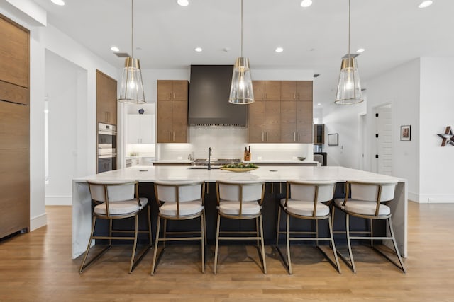 kitchen featuring pendant lighting, a kitchen breakfast bar, and a large island with sink