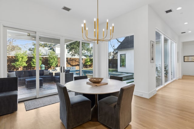 dining area featuring plenty of natural light, a chandelier, and light wood-type flooring